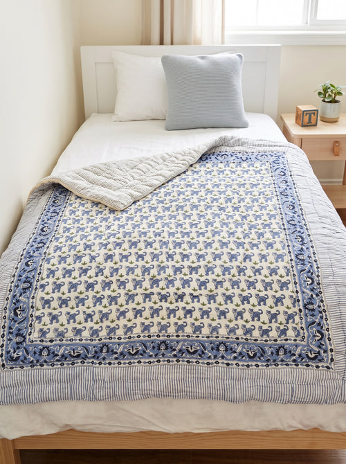 PEXX blue tiger print reversible cotton baby quilt, 100 x 100 cm — hero on bed with reverse